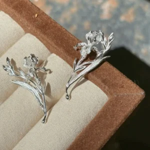 Handmade silver iris earrings close up with carved flowers, unopened buds, and blade leaves