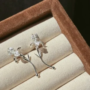 Handmade curved stem iris earrings in S925 shown at a side angle inside a velvet box