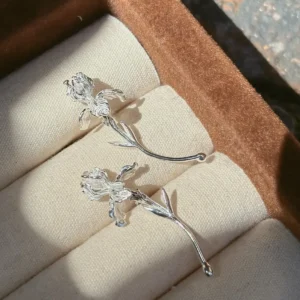 Silver curved stem iris earrings close up with veined petals and restrained leaf details