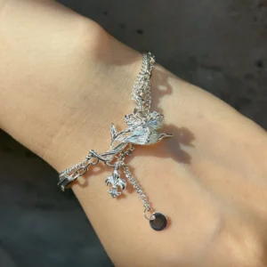 Personalized iris bracelet worn on the wrist with layered chains and moving charms