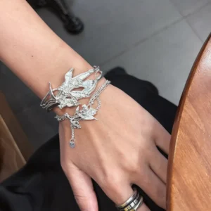 Handmade silver bracelet with iris flower and personalized charms worn beside a dark outfit