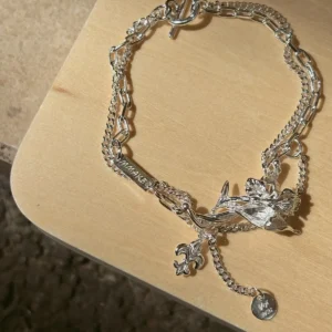 Personalized silver iris bracelet with engravable plate and round medallion shown flat