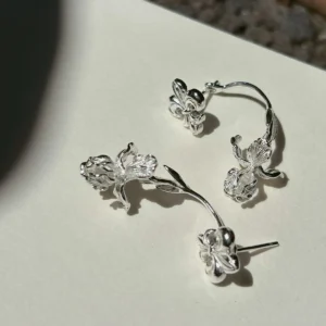Ear jacket earrings in sterling silver with fleur-de-lis front studs and separate botanical back pieces