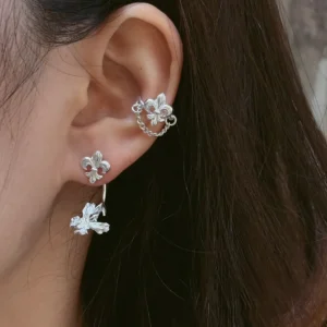 Silver iris ear jacket earring worn with a fleur-de-lis stud at the lobe and a long iris bloom suspended behind