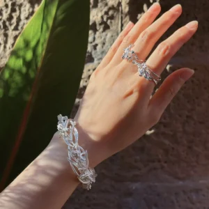 Statement flower cuff bracelet worn on the wrist with raised iris blooms and openwork leaves