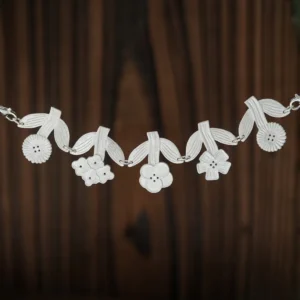 Sterling silver flower necklace laid flat on dark wood, five linked blooms hanging from ribbed leaves