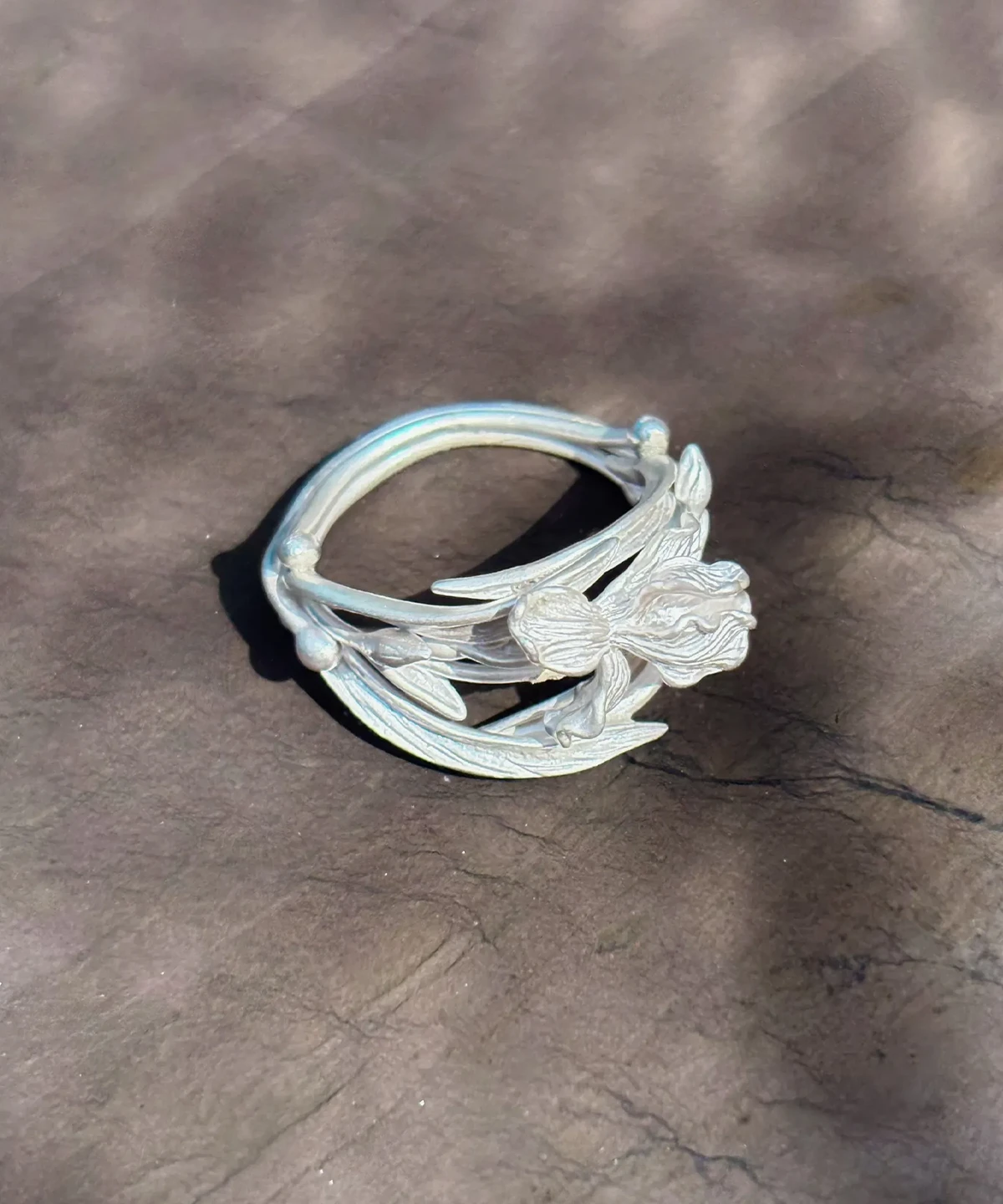 Silver iris ring on stone, openwork band of stems and leaves with rounded bud terminals