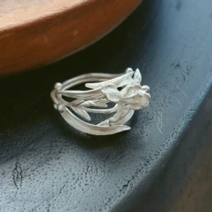 Handmade silver iris ring in S925 sterling silver resting on a dark vessel rim