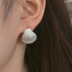 Plain scallop Silver shell earrings worn on the ear in 990 pure silver, fluting and nothing else