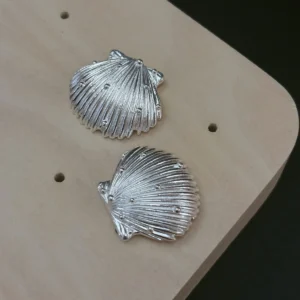 Ribbed scallop silver shell earrings in 990 pure silver, raised granules scattered across the fluting