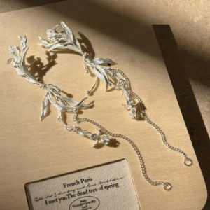 Sterling silver iris floral dangle earrings displayed as an asymmetric pair with long chains
