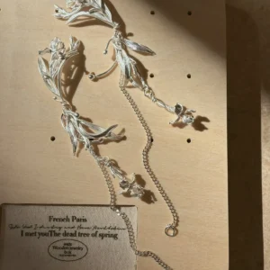Silver flower dangle earrings arranged as a non-identical pair with long chains and iris charms