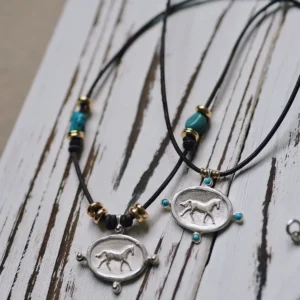 Boho sterling silver horse necklace with turquoise accents on leather cord