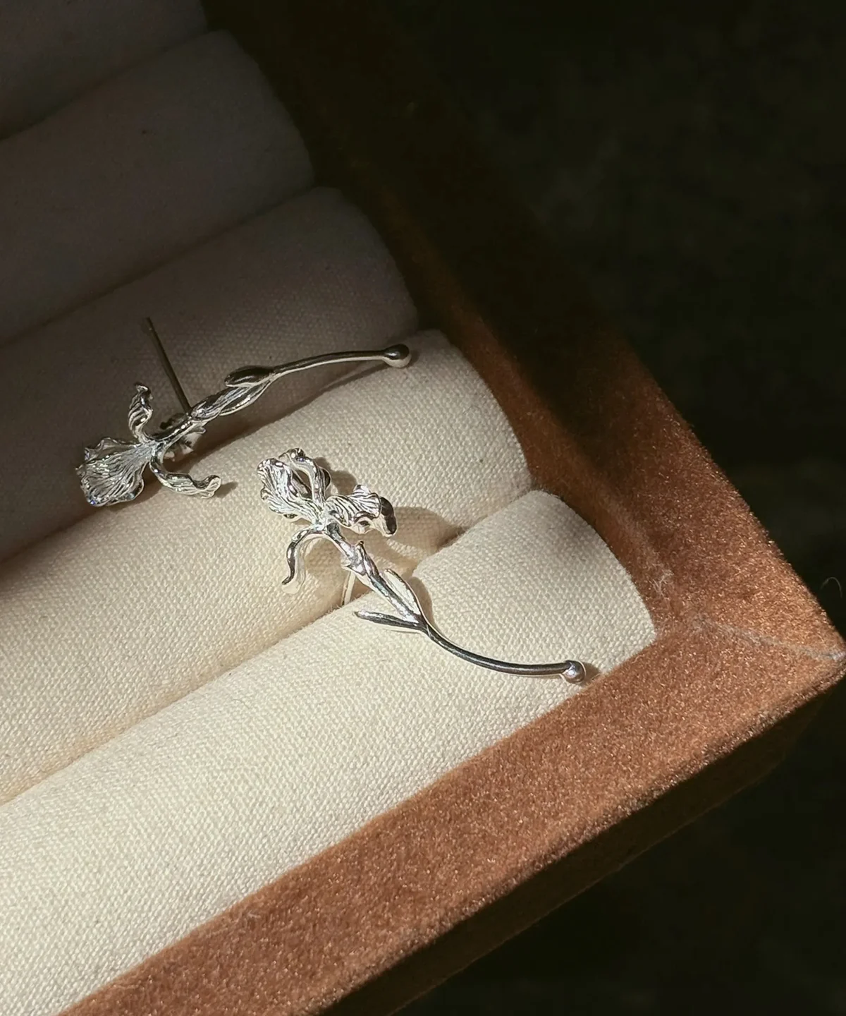 S925 silver iris earrings with single flowers on long curved stems in a jewelry box