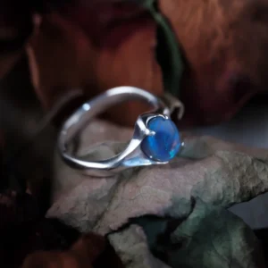 Natural blue opal ring in handcrafted S925 sterling silver displayed on dried leaves