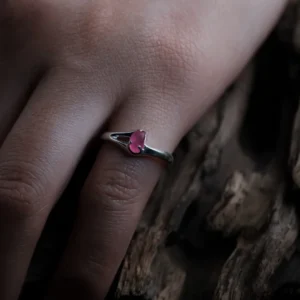 Delicate natural pink sapphire ring in S925 sterling silver worn beside textured wood