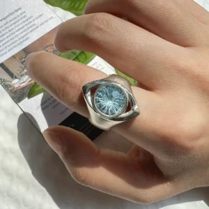 Six Eyes Ring with blue topaz gemstone worn on a finger, showing the detailed silver eye-inspired design