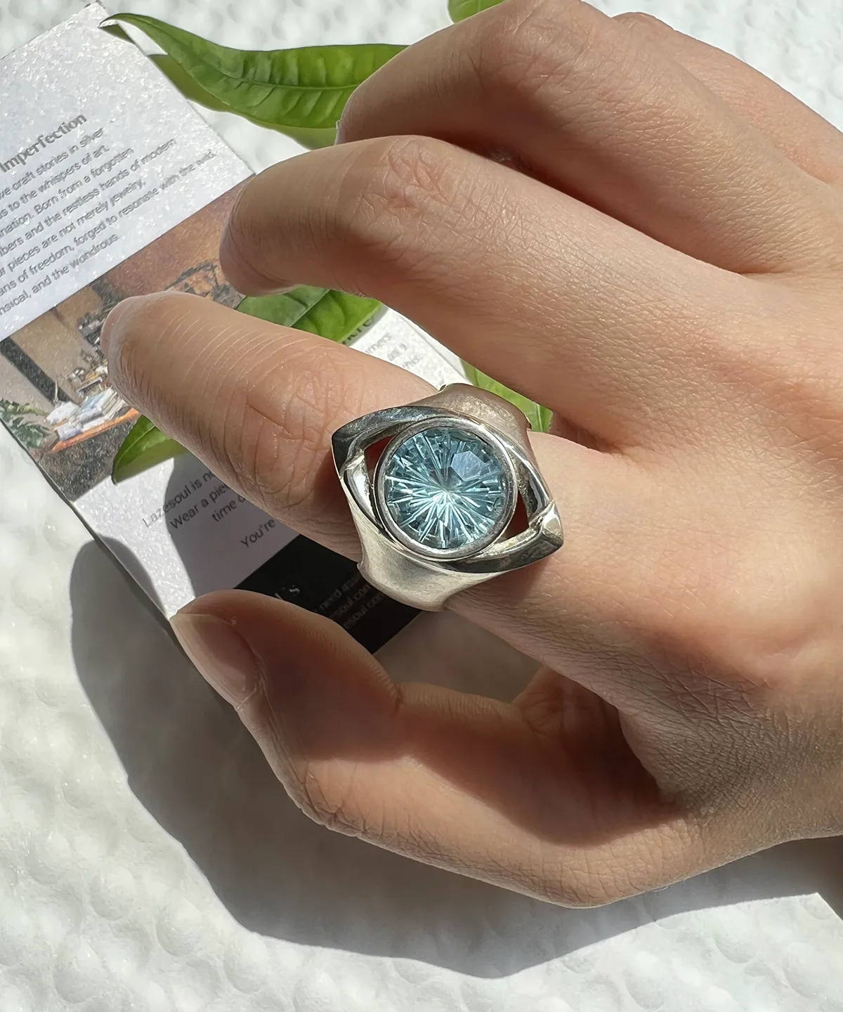 Six Eyes Ring with blue topaz gemstone worn on a finger, showing the detailed silver eye-inspired design