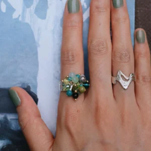 Unripe Green Blackcurrant ring worn against blue abstract artwork