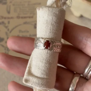 Natural Nanhong agate ring in 999 fine silver displayed around a rolled linen strip