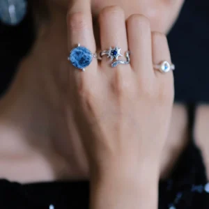 Silver lapis lazuli ring face shown beside blue and pale stone rings