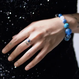 Silver star ring worn on an extended hand against a black dress