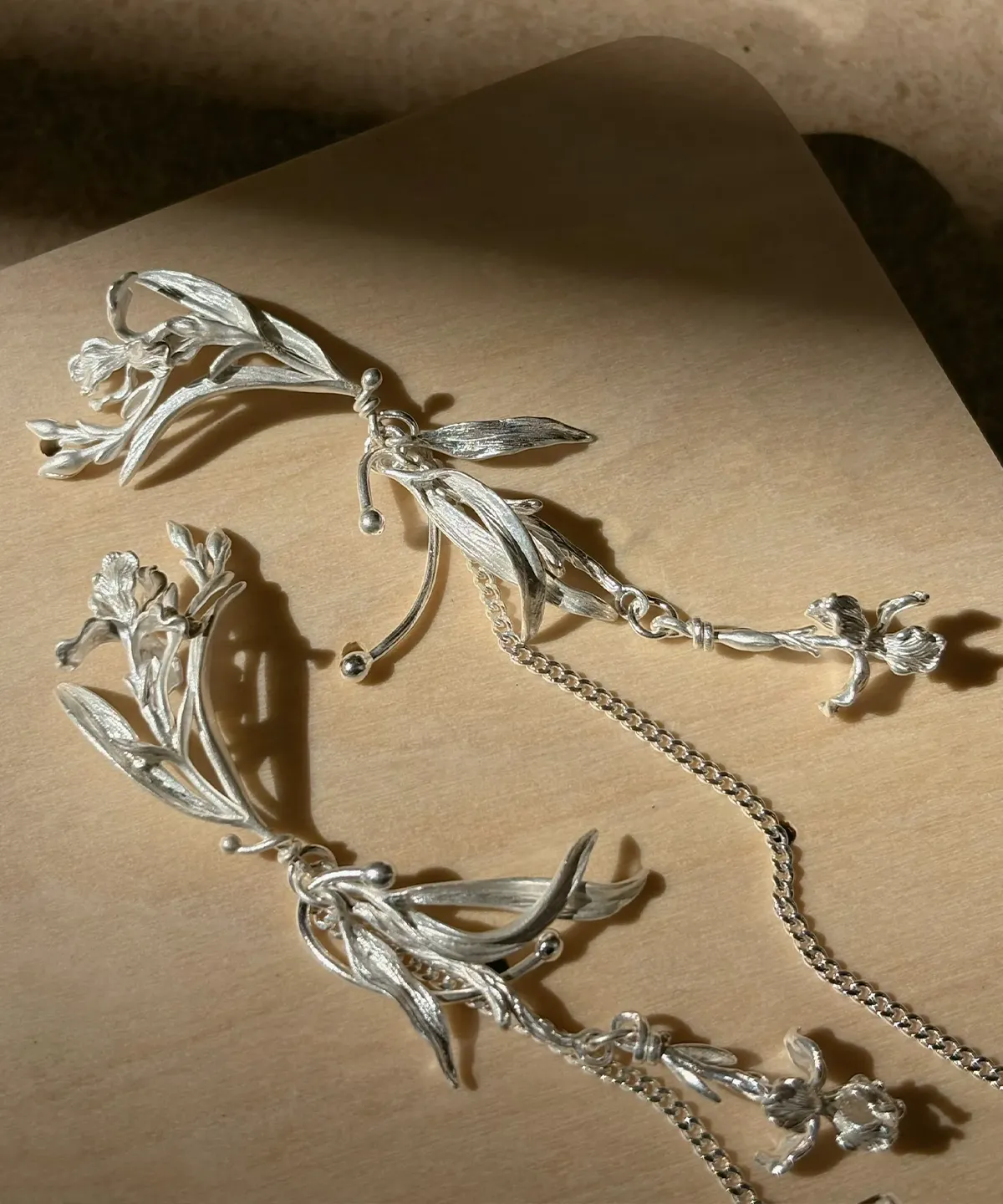 S925 silver iris floral dangle earrings arranged in warm side light