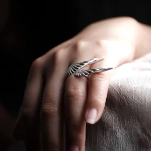 Dual Wing silver ring worn on a relaxed hand in natural light