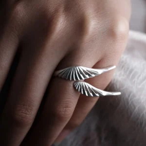 Made-to-size sterling silver wing ring worn on a finger in close-up