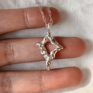 Open four-point star pendant formed from flowing 999 fine silver lines on a silver chain