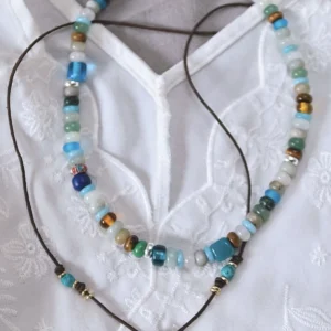 Amazonite necklace arranged above a separate leather-cord pendant necklace
