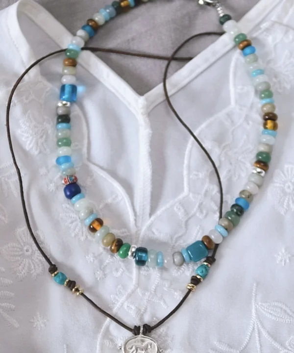 Amazonite necklace arranged above a separate leather-cord pendant necklace