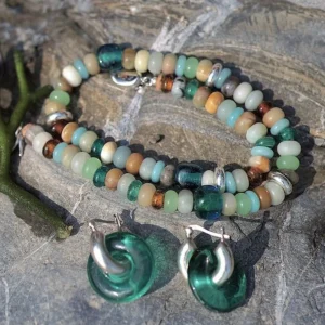 Amazonite necklace coiled on rock with separate green glass earrings