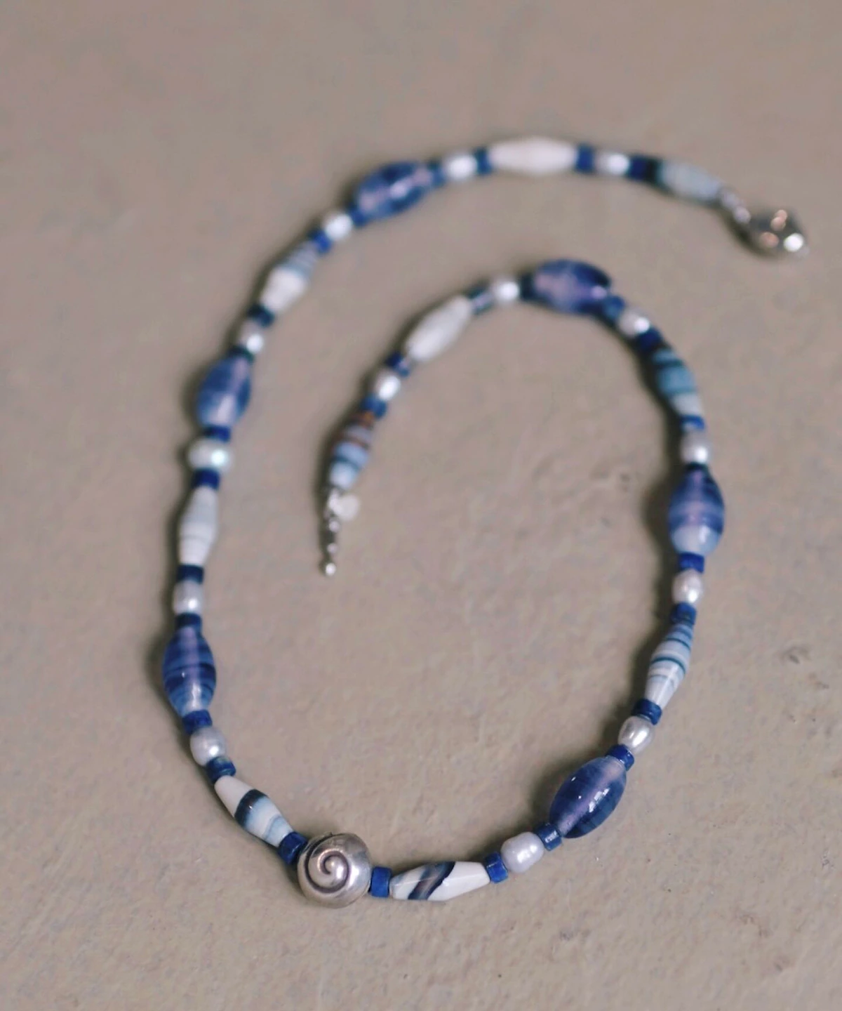 Blue agate beaded necklace laid flat with its clasp visible
