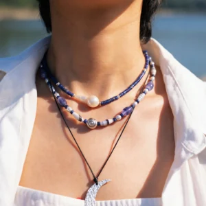 Blue agate necklace layered with a pearl strand and long silver pendant