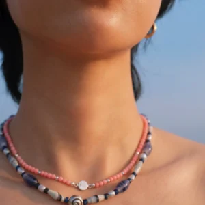 Blue agate necklace layered below a pink rhodonite necklace at the collarbone