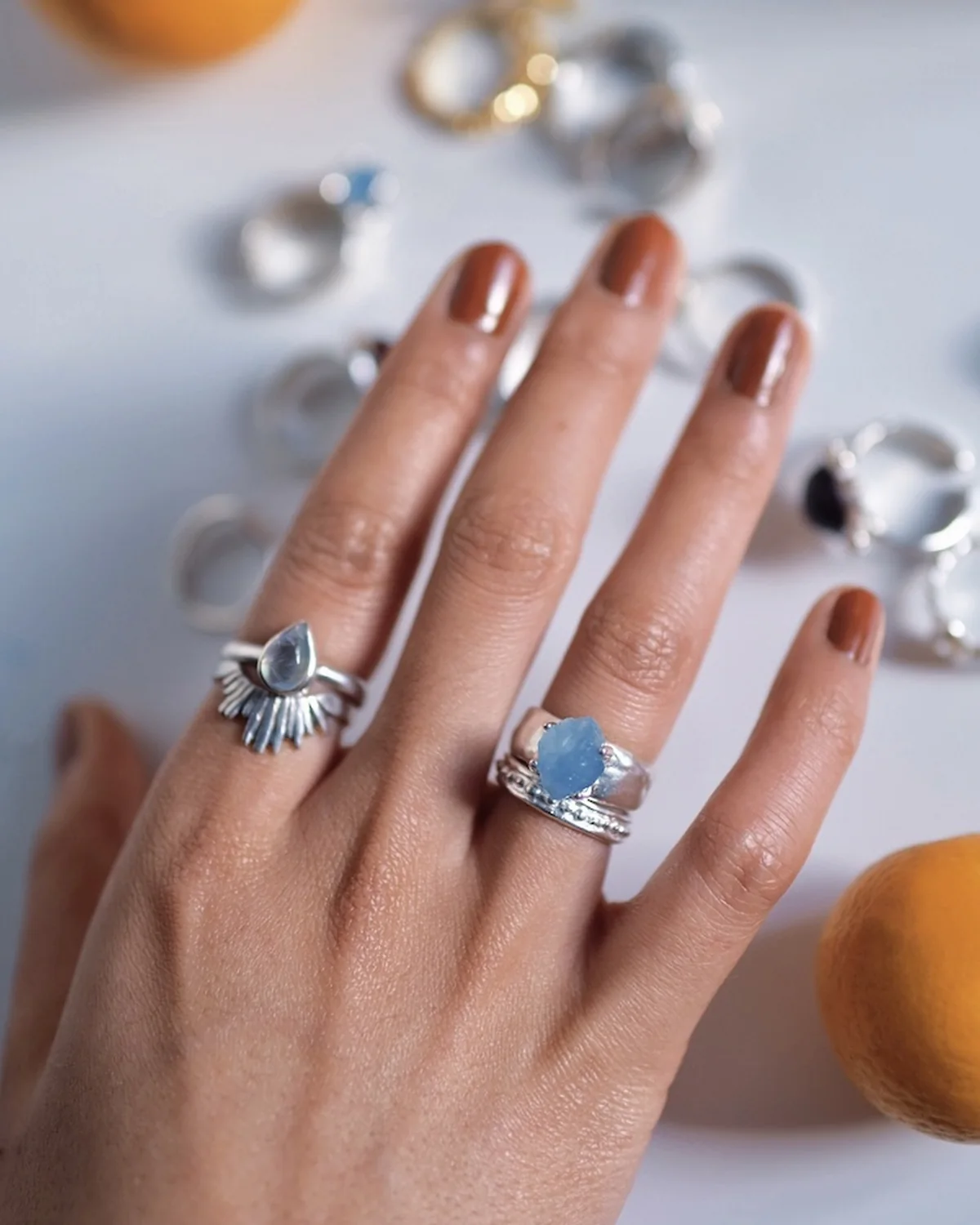 Blue gemstone rings balanced by sculptural silver bands on one hand