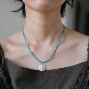 Dragonfly necklace in S925 silver with blue-green glass beads, worn at the collarbone