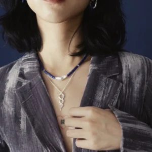 Lapis lazuli pearl necklace layered above a silver snake pendant