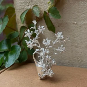 Magnolia flowers arranged in a miniature 990 silver vase