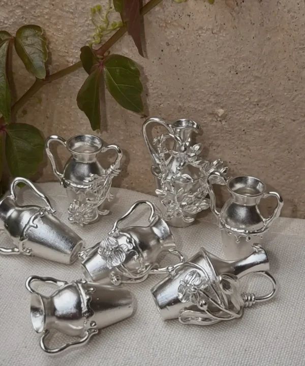 Collection of miniature 990 silver vase pendants with sculpted botanical details