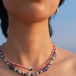 Rhodonite yin yang necklace layered above a shell bead necklace