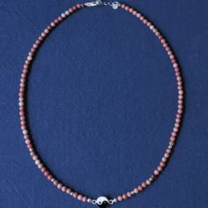 Full rhodonite yin yang necklace with lobster clasp and extender on blue cloth