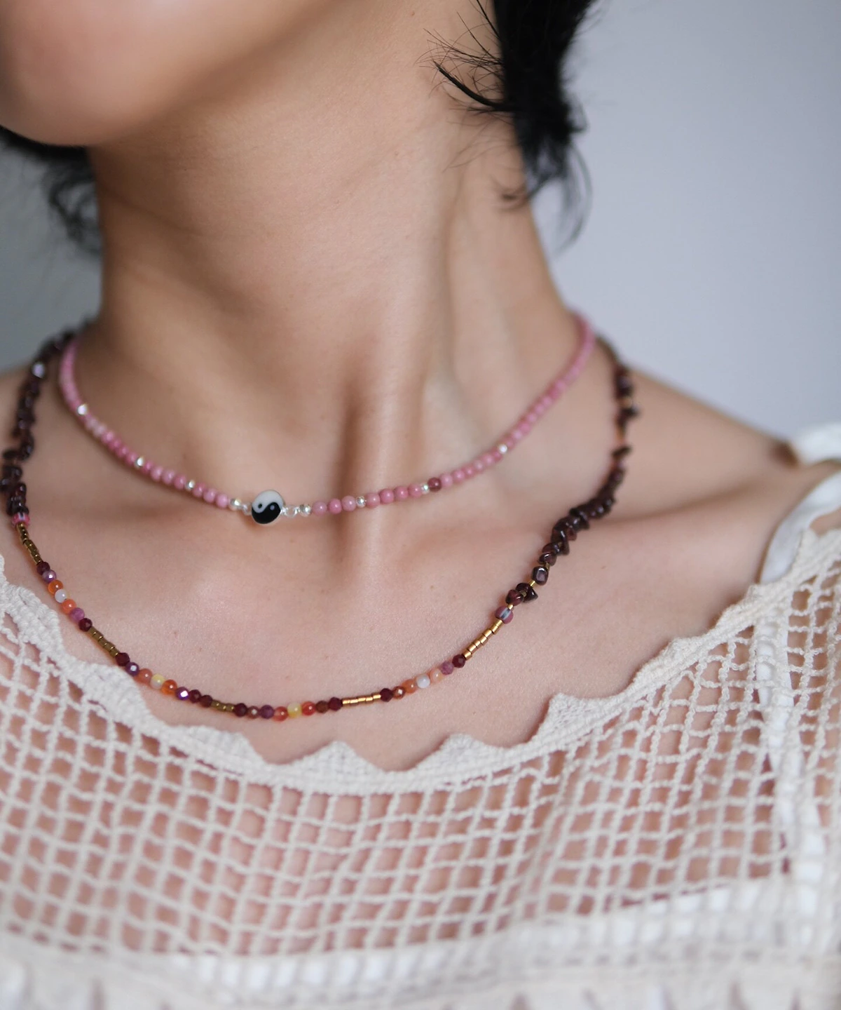 Rhodonite yin yang necklace layered with a longer dark bead strand
