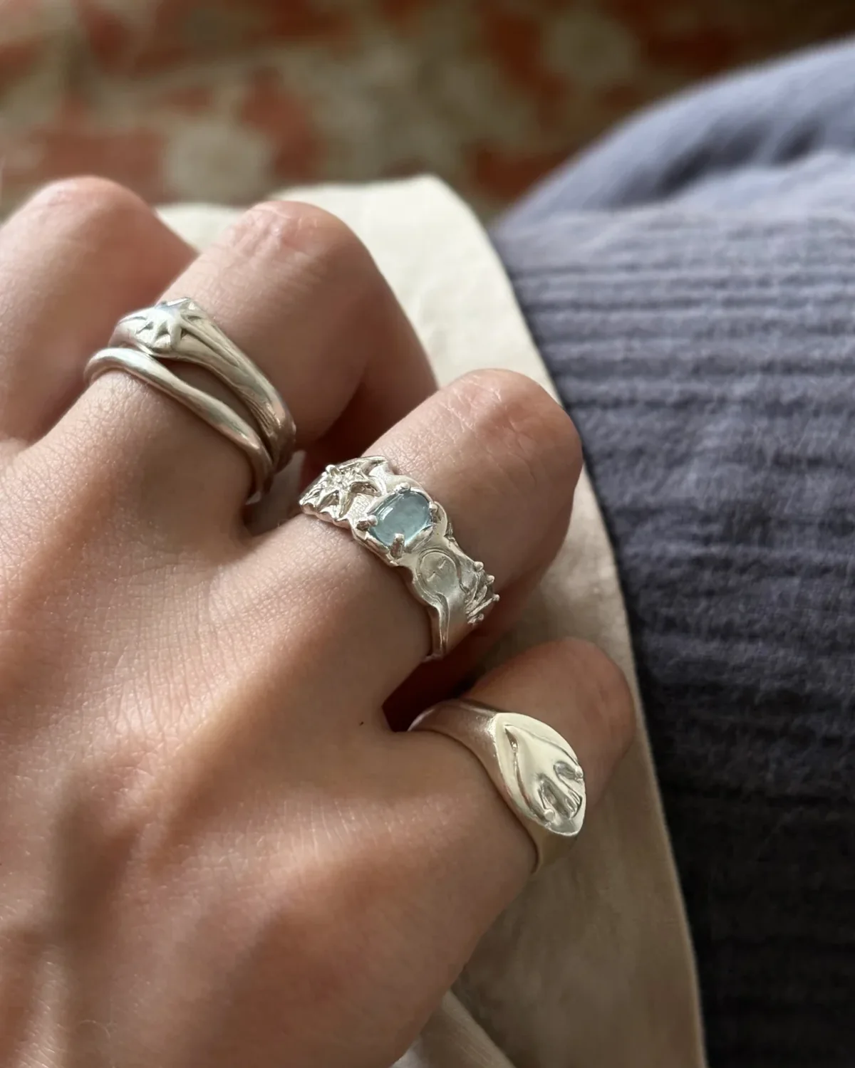 Three silver rings spaced across bent fingers during everyday wear