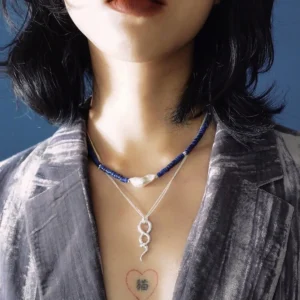 Lapis lazuli and baroque pearl necklace worn close to the collarbone