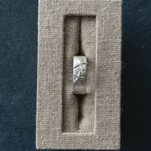 999 fine silver starfish ring displayed upright in a narrow linen jewelry box