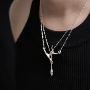Sterling silver bow and arrow necklace worn close against a black top