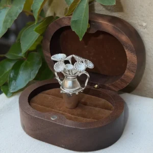 Umbrella algae forms in a miniature 990 silver vase