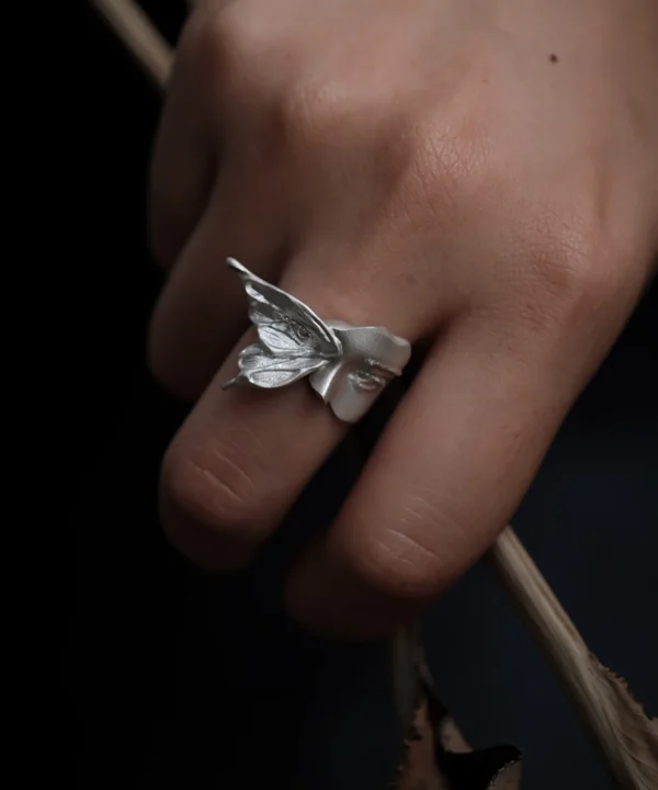 Home 6 Gaze sterling silver moth ring worn on a hand, showing the raised wing and sculpted face